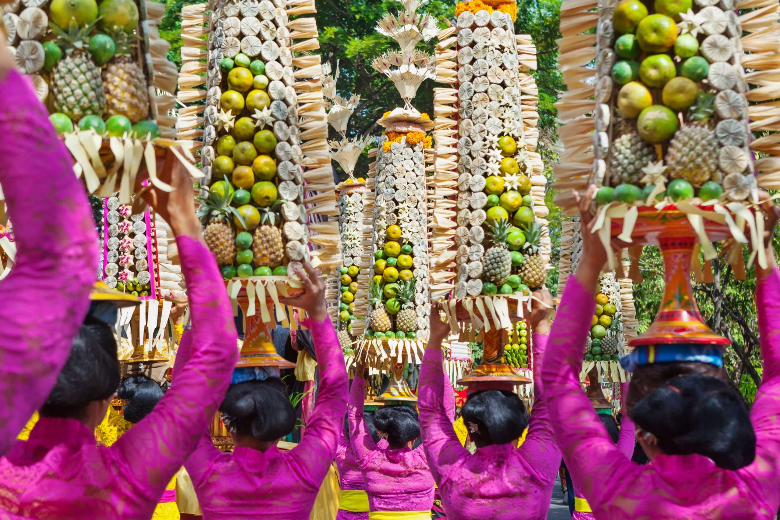 Balinese women in traditional costumes with offerings for ceremony