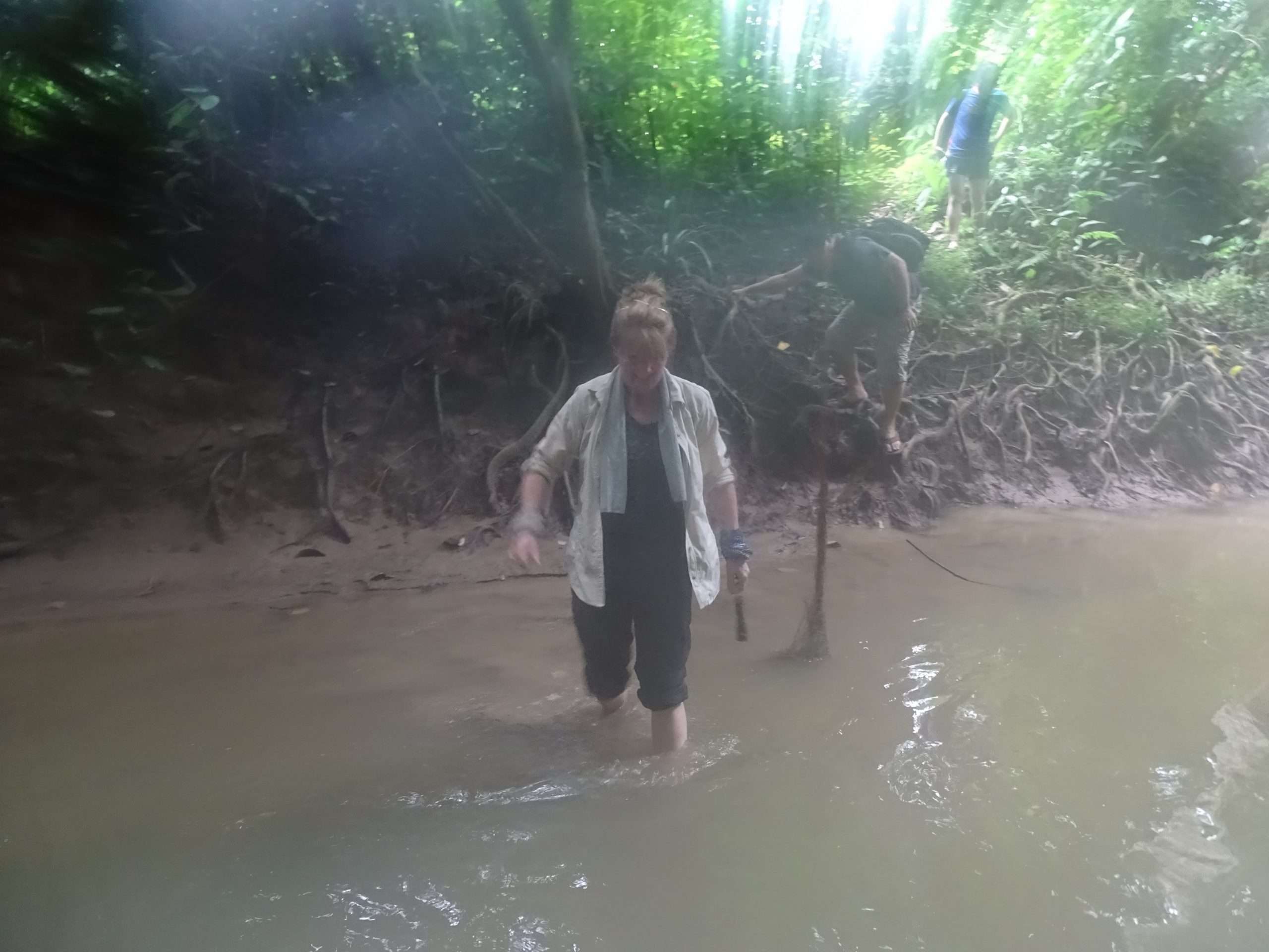 Angela wades across a river.